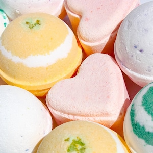 May include: Assortment of colorful bath bombs in various shapes, including round, heart, and swirl designs. The bath bombs are made with natural ingredients and are perfect for a relaxing bath.