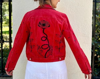 May include: Red denim jacket with a black embroidered poppy flower design on the back.