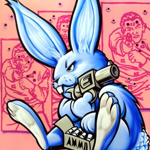 Puede incluir: Un conejo azul con una pistola y una caja de municiones. El conejo está sentado sobre un fondo rosa con siluetas de tiro al blanco en el fondo.