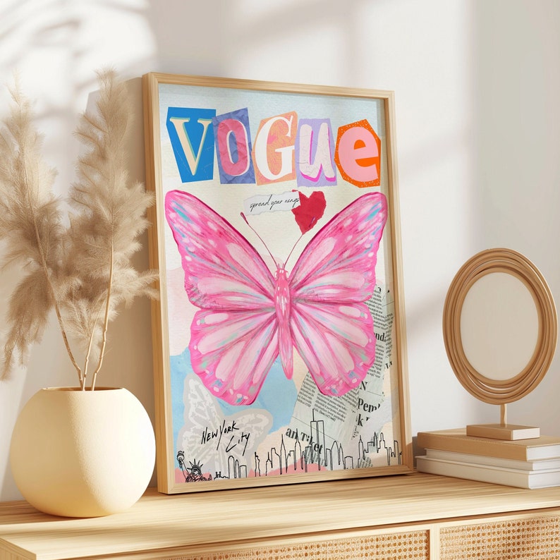 May include: A framed print with a collage aesthetic featuring a pink butterfly, the word "VOGUE" in colourful letters, and the phrase "spread your wings". The background includes a cityscape and newspaper clippings.