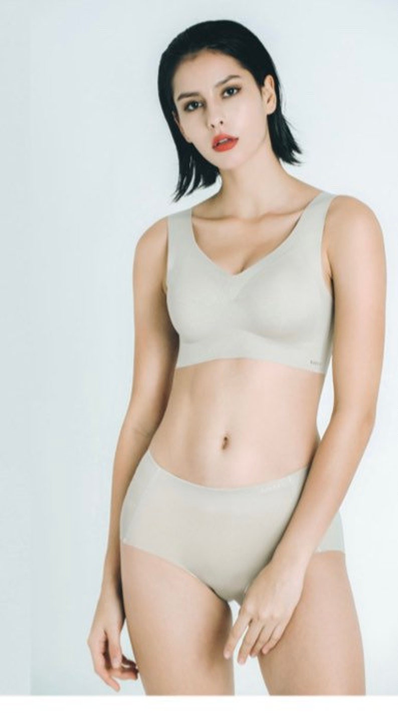 May include: A light beige seamless bra and underwear set. The bra has a V-neck and the underwear has a high waist.