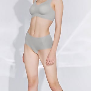 May include: A woman is wearing a light grey seamless bra and matching underwear. She is wearing gold high-heeled sandals.
