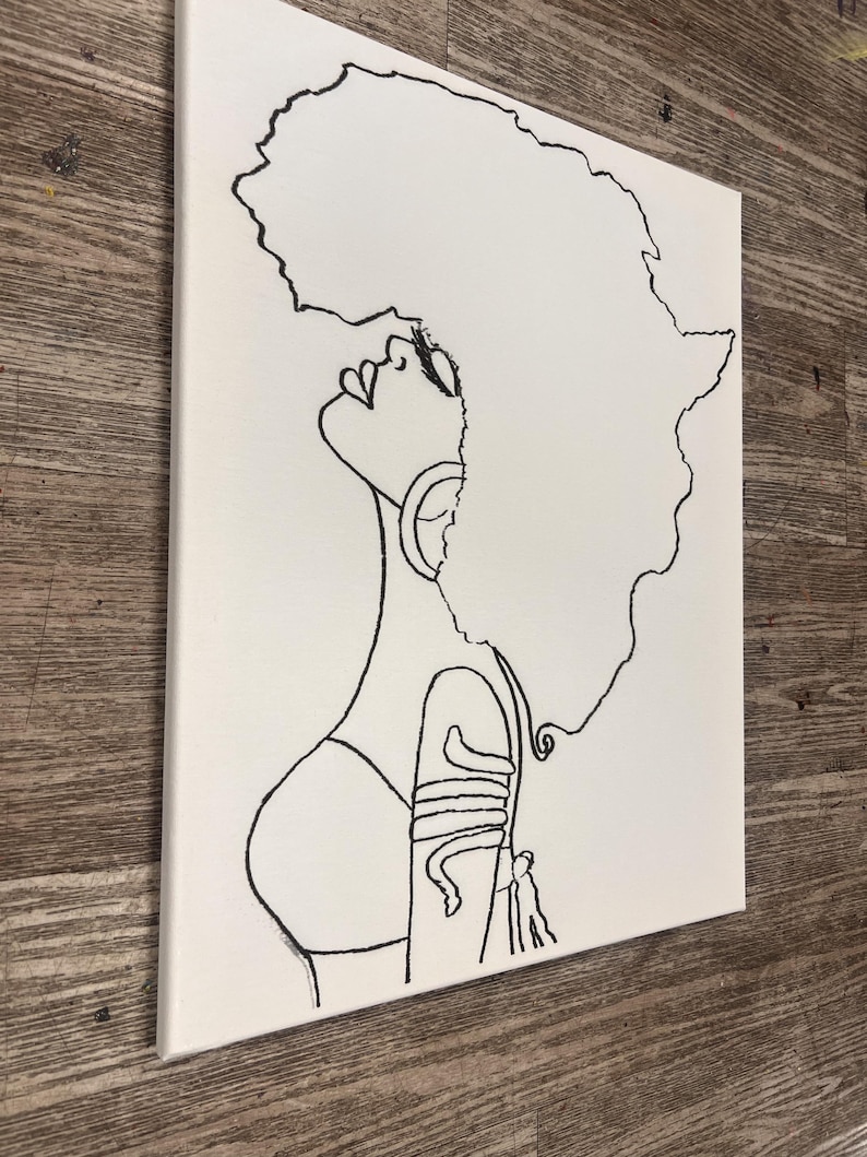 K&ouml;nnte beinhalten: Linienzeichnung eines Frauenportr&auml;ts mit Afrofrisur. Die Frau tr&auml;gt ein schlichtes Oberteil und ein Armband am Arm. Das Bild ist in Schwarzwei&szlig; auf einer wei&szlig;en Leinwand gemalt.