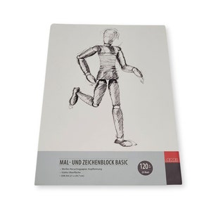 Könnte beinhalten: Ein weißer Zeichenblock mit einer Skizze einer laufenden Künstlerpuppe. Auf dem Block steht "MAL- UND ZEICHENBLOCK BASIC" und "DIN A4 (21 x 29,7 cm)". Er enthält 120 Blatt.