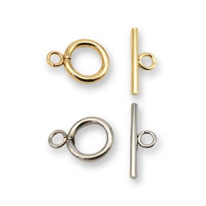 Puede incluir: Dos juegos de cierres de palanca de oro y plata para la elaboración de joyas. Cada juego incluye un anillo redondo y una barra recta.