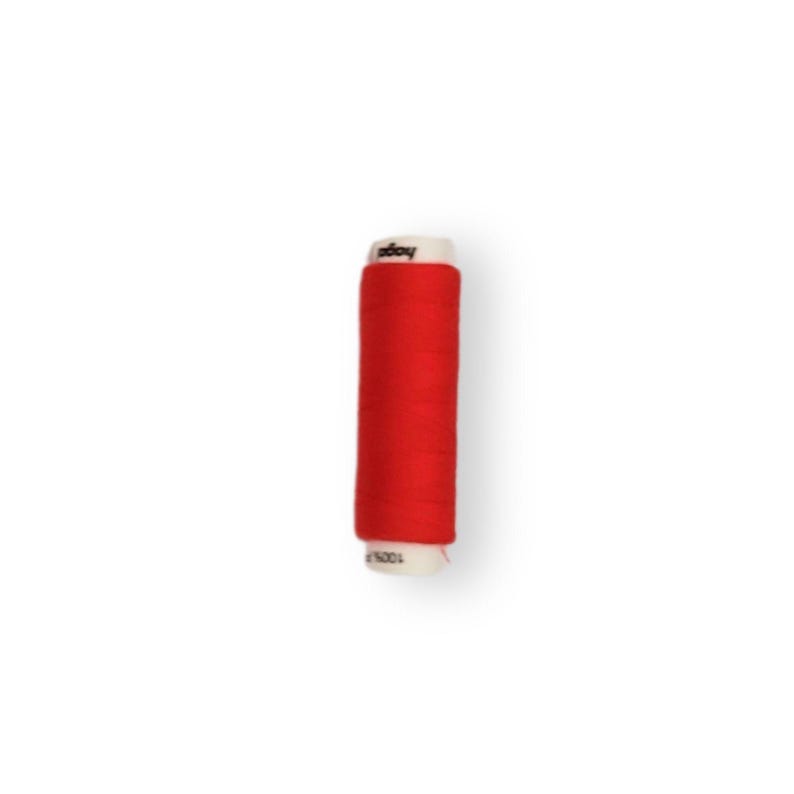 May include: A spool of red thread with a white label that says "decoy".