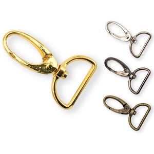 May include: Three metal swivel clasps in gold, silver, and antique brass finishes. Each clasp has a D-ring and a spring-loaded gate.