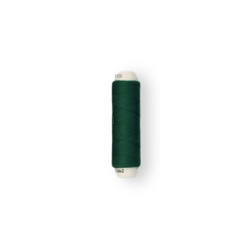 May include: A spool of dark green thread with white labels that read "1120" and "114x2".