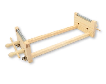 May include: A wooden frame with two adjustable clamps and a metal rod. The frame is made of natural wood and is designed for stretching fabric.