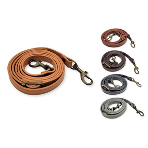 May include: Four leather straps with metal clasps in different colours: brown, dark brown, grey, and light grey. The straps are coiled and ready to be used as a replacement strap for a bag or purse.