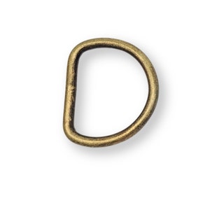 Könnte beinhalten: Ein goldfarbener D-Ring aus Metall. Diese Art von Ring wird oft zum Anbringen von Riemen, Griffen oder anderem Zubehör verwendet.