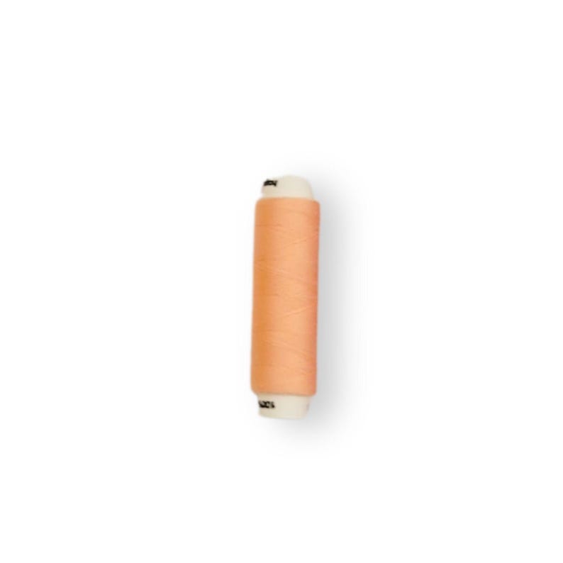 May include: A spool of peach-colored thread.