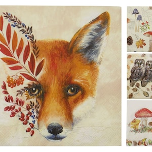 May include: A collection of decorative paper napkins with autumnal designs. One napkin displays a watercolour painting of a fox with autumn leaves. Other napkins feature mushrooms, owls, and falling leaves.