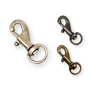 May include: Three metal swivel snap hooks in silver, black, and brass.