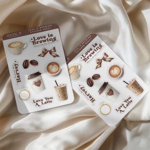 Könnte beinhalten: Zwei Stickerbögen mit Kaffeemotiven. Jeder Bogen zeigt Kaffeetassen, Bohnen und den Text "Love is Brewing" und "Love You A Latte". Ein Bogen enthält "Future Mrs. Harvey" und einen Ring.
