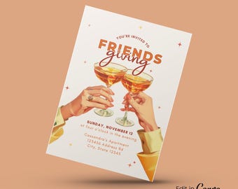 May include: A digital invitation with the text "FRIENDSgiving" in orange and brown. The invitation features two hands toasting with cocktail glasses. The invitation includes the date, time, and address. The invitation is 12.7 x 17.8 cm.
