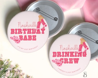 May include: Two pink and white round buttons with text and images. The first button says "Nashville Birthday Babe" with a pink cowboy hat and pink boots. The second button says "Nashville Drinking Crew" with a pink cowboy hat and pink boots. Both buttons have the text "It's my 21st Birthday" and "Lindsey's 21st Birthday" respectively.