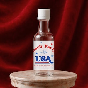 Può includere: Una bottiglia in miniatura di vetro trasparente con tappo a vite bianco. L'etichetta presenta testo rosso e blu con la scritta Bach Party in the USA e MARA'S BACHELORETTE, decorata con piccole stelle rosse e blu e due linee orizzontali.