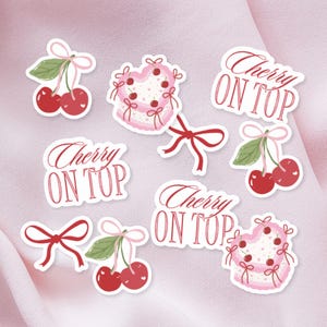Può includere: Una collezione di adesivi con ciliegie, fiocchi e torte a forma di cuore. Gli adesivi hanno uno sfondo bianco e sono decorati con accenti rossi, rosa e verdi. Il testo "Cherry ON TOP" è incluso.