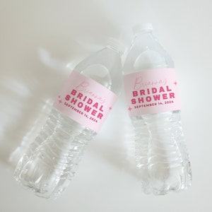 May include: Two clear plastic water bottles with pink labels that say "Brianna's Bridal Shower" and the date "September 14, 2024".