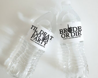 May include: Two clear plastic water bottles with black and white labels. The labels say "Til Death Do Us Party" and "Bride or Die". Both labels have a skeleton hand making a middle finger gesture. The labels also say "Tara's Bachelorette".