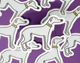 May include: A set of grey dog stickers with yellow collars and floral accents. The stickers are on a purple background.