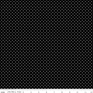 May include: A black fabric featuring a repeating pattern of small white polka dots, displayed alongside a white ruler measuring 12 inches to provide a clear scale of the textile design and the size of the dots.