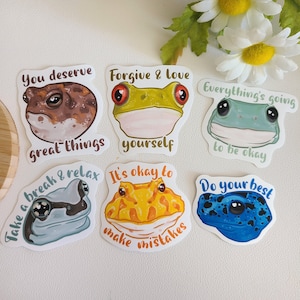May include: Nine colorful frog stickers with motivational quotes. The quotes include "You deserve great things", "Forgive & love yourself", "Everything's going to be okay", "Take a break & relax", "It's okay to make mistakes", and "Do your best".
