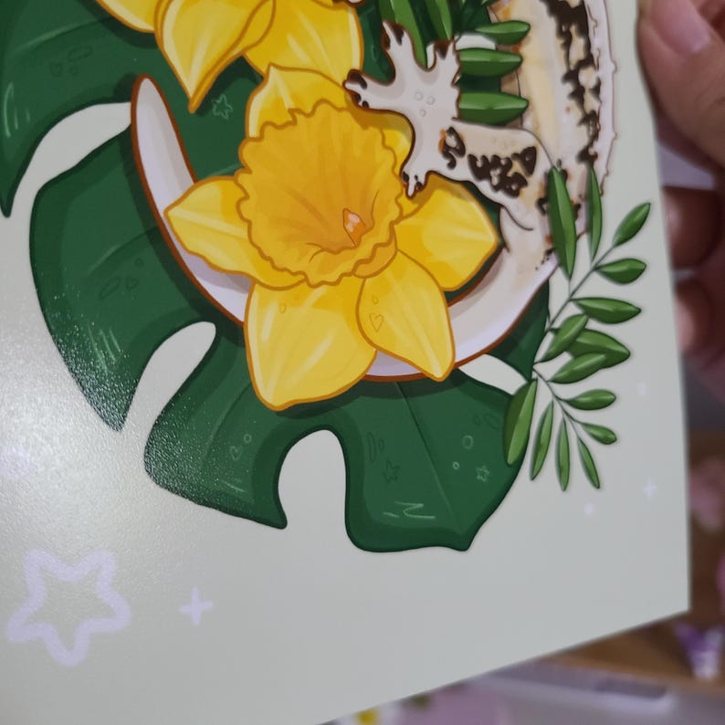 May include: A vibrant illustration featuring a bright yellow daffodil with a white outline, set against a backdrop of green monstera leaves. Additional botanical elements include sprigs of green leaves and a white, textured shape. The overall design has a whimsical, artistic feel.