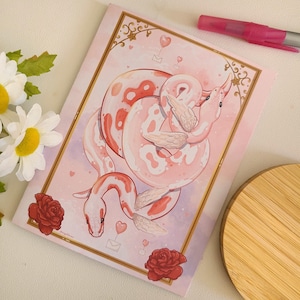 May include: A pink and white snake with wings wrapped around itself. The snake is on a pink background with hearts and a letter. The snake is a Valentine's Day themed illustration.