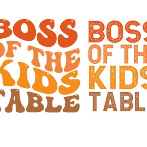 Op de afbeelding: Oranje, gele en bruine tekst op een witte achtergrond luidt "Boss of the Kids Table". De tekst is in een retro, golvend lettertype.