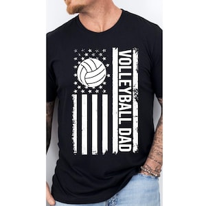 May include: Black t-shirt with a white distressed American flag design and a volleyball graphic. The text "Volleyball Dad" is printed vertically on the right side of the flag.