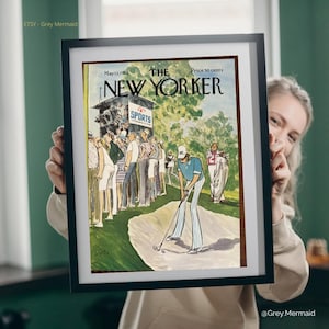 May include: Framed vintage New Yorker magazine cover from May 13, 1974, featuring a golf scene. The artwork depicts a golfer in blue and white striped pants, with spectators in the background. The magazine title and price are visible.