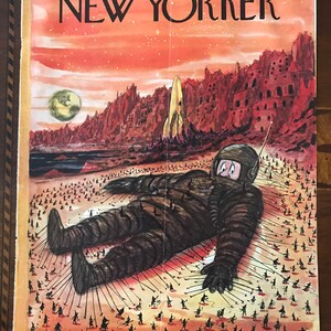 May include: The New Yorker magazine cover from 14 June 1958, features an illustration of a giant astronaut lying on a red desert landscape.  Tiny figures are pulling ropes attached to the astronaut's body.  The cover title "The New Yorker" is printed in black and white at the top of the cover.  The price is 25 cents.