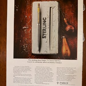 Peut inclure: Publicit&eacute; pour un stylo &agrave; bille Parker 75 Classic. Le stylo argent&eacute; avec des d&eacute;tails dor&eacute;s est pr&eacute;sent&eacute; sur un &eacute;tui argent&eacute; avec le mot "STERLING" en relief. Le texte met en avant les caract&eacute;ristiques et la valeur du stylo.