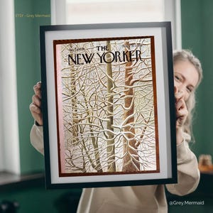 May include: A framed print of a New Yorker magazine cover featuring a winter scene with snow-covered trees. The cover art has a brown and white color palette, with the magazine title at the top. The frame is black.
