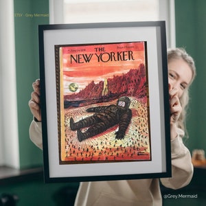 May include: A vintage New Yorker magazine cover from June 14, 1958, featuring an illustration of a large, futuristic astronaut lying on a desert landscape with tiny people surrounding it. The cover reads "The New Yorker" with the price "25 cents".