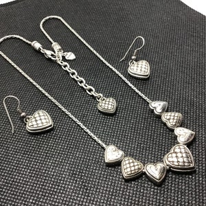 Puede incluir: Un collar de plata con una cadena y cinco colgantes en forma de coraz&oacute;n. El collar se combina con pendientes de coraz&oacute;n de plata a juego.