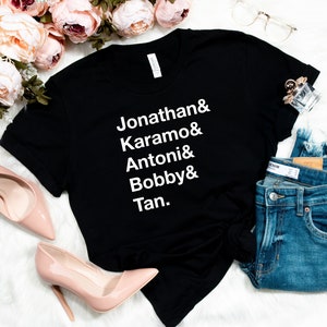 May include: Black t-shirt with white text that reads "Jonathan & Karamo & Antoni & Bobby & Tan."