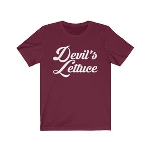 May include: Burgundy short-sleeved t-shirt with white text that reads "Devil's Lettuce" in a retro font.