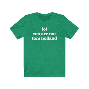 May include: Green t-shirt with white text that reads "lol you are not tom holland".