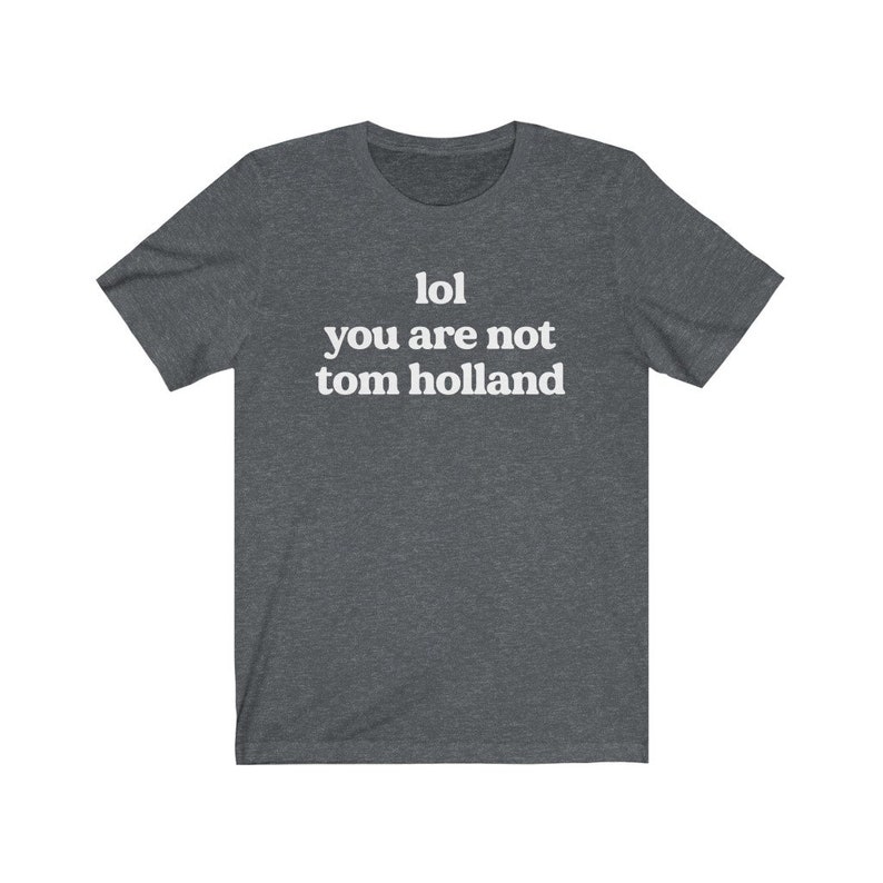 May include: A dark heather grey t-shirt with the text "lol you are not tom holland" printed in white.