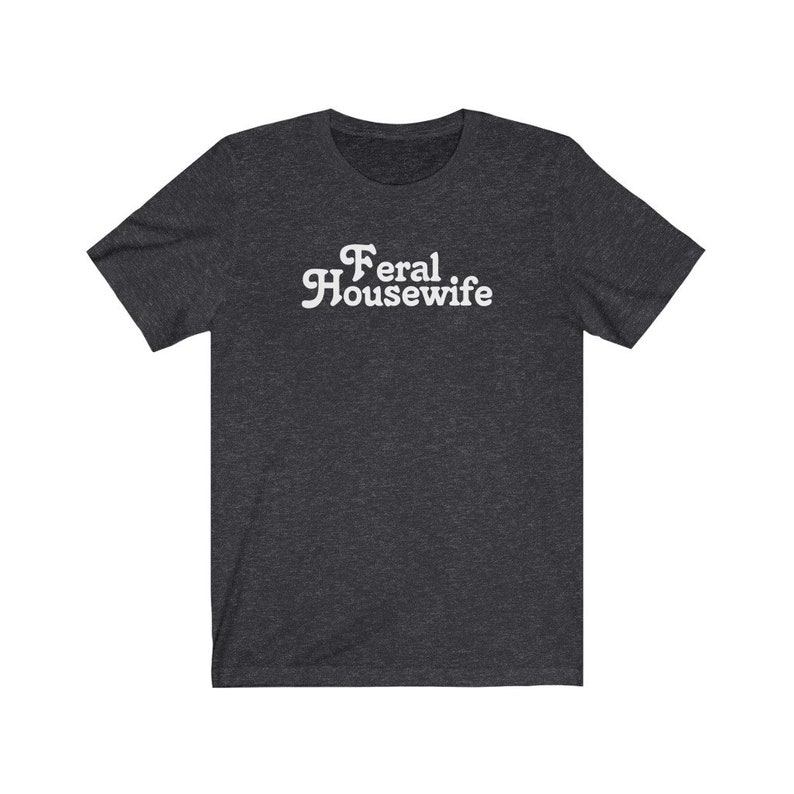May include: A dark heather grey t-shirt with the text "Feral Housewife" printed in white.