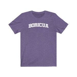 May include: Purple short-sleeved t-shirt with the word "BORICUA" printed in white on the front.