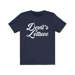 May include: A navy blue t-shirt with white text that reads "Devil's Lettuce" in a retro font.