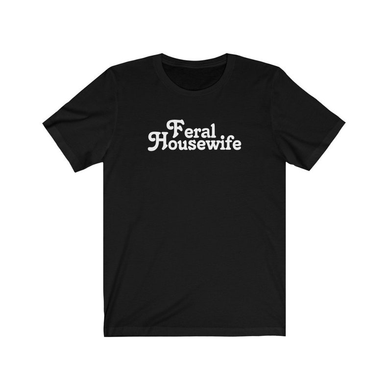 May include: Black short-sleeved t-shirt with white text that reads "Feral Housewife".