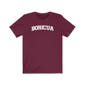 May include: A maroon t-shirt with the word "BORICUA" printed in white on the front.