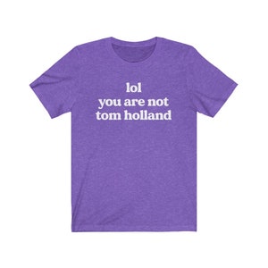 May include: Purple short-sleeved t-shirt with white text that reads "lol you are not tom holland".