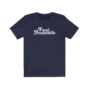 May include: A navy blue t-shirt with white text that reads "Feral Housewife".