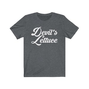 May include: A dark heather grey t-shirt with the text "Devil's Lettuce" in white cursive lettering.